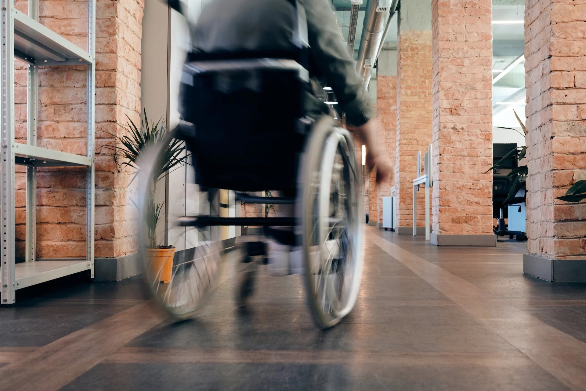 man in wheelchair in building meeting accessibility requirements